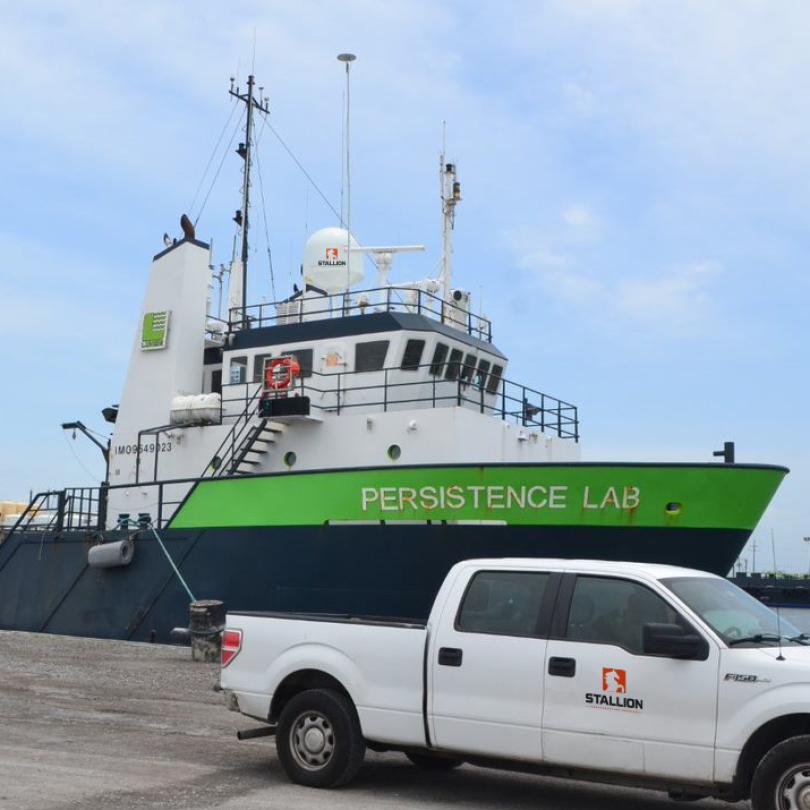 Truck on a dock next to cargo ship