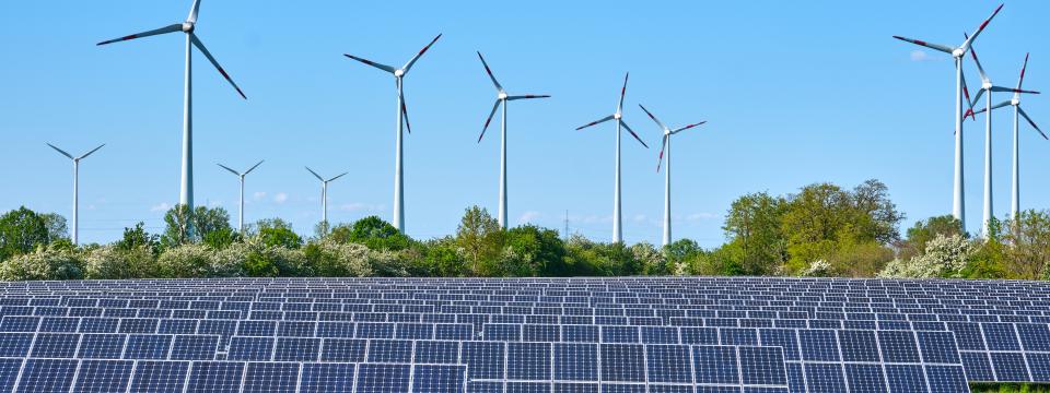 Solar panels next to wind turbines